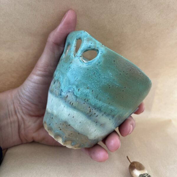 Tasse grés vert ajourée Tasse sans anse en grès avec émaux en cascade de vert, tenue dans une main pour montrer sa taille idéale pour toutes vos boissons chaudes