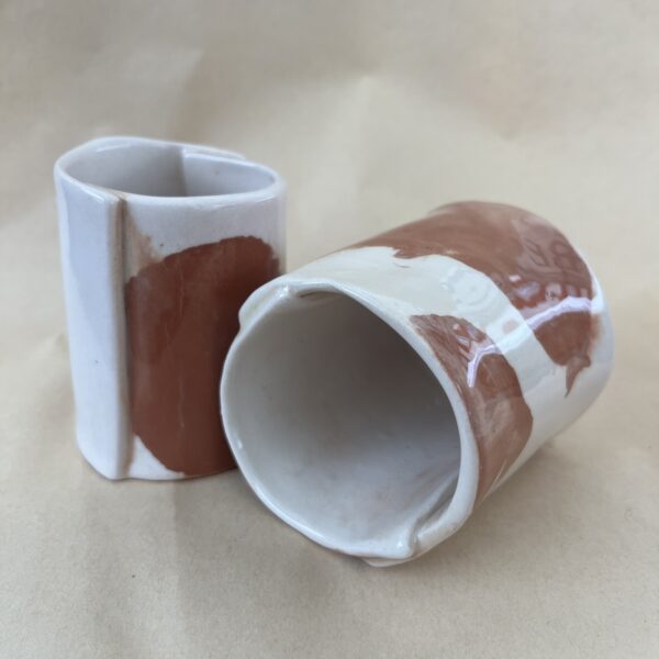 deux tasse marbrée en faience rouge et blanche présentée pour qu'on y voir le côté et l'intérieur